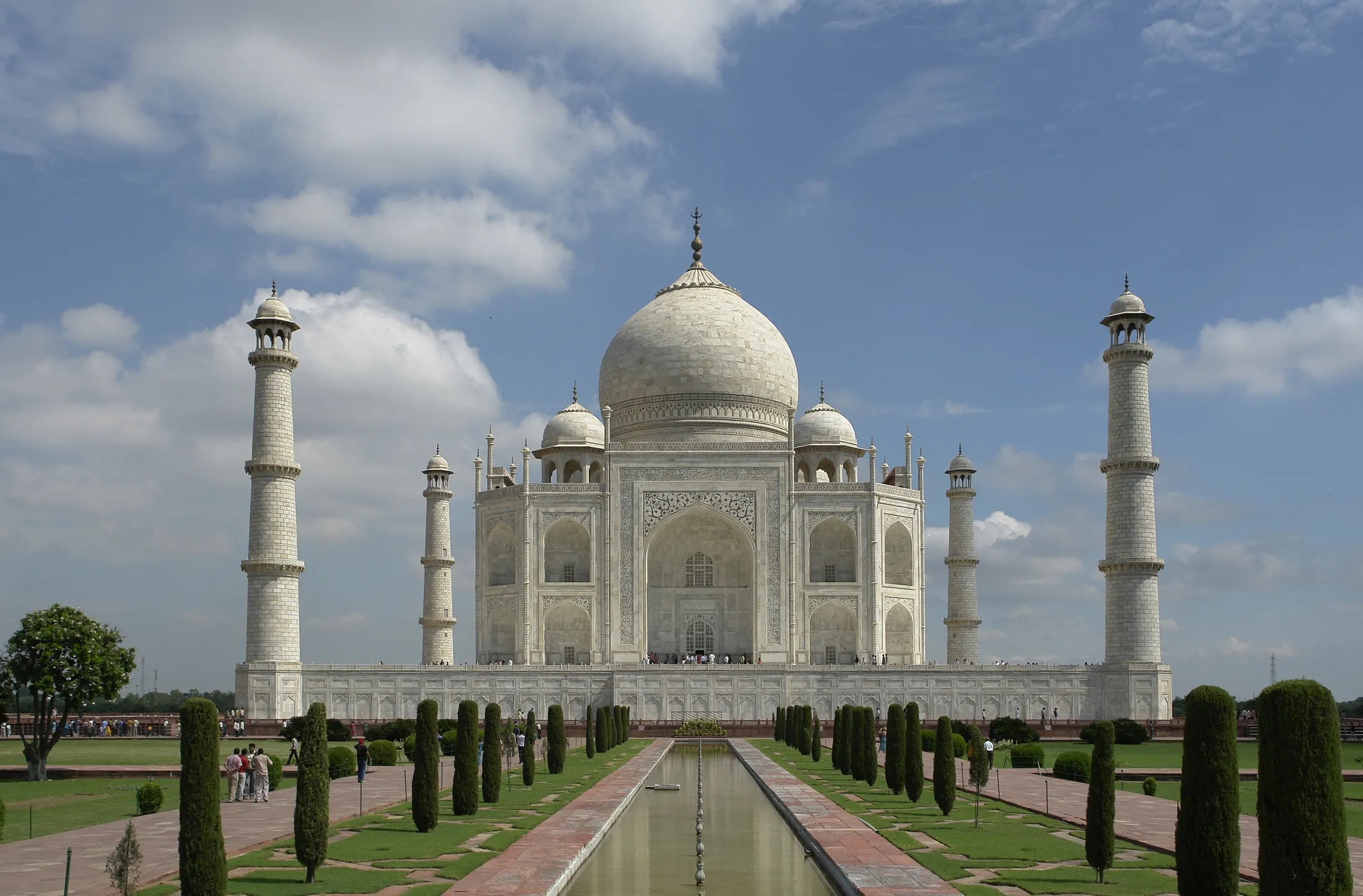 A white marble mausoleum with four minarets seen down a formal garden