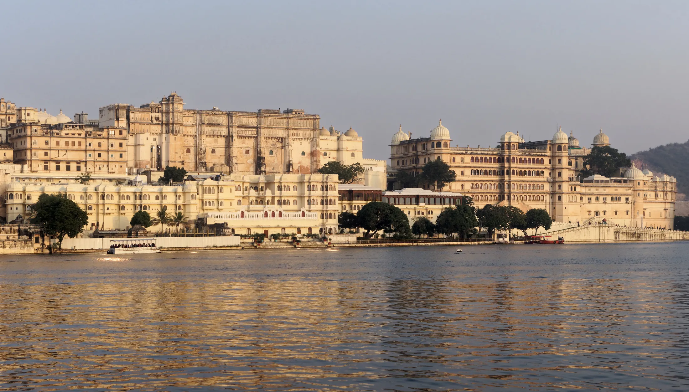 A long palace facade along a lake shore in late afternoon light