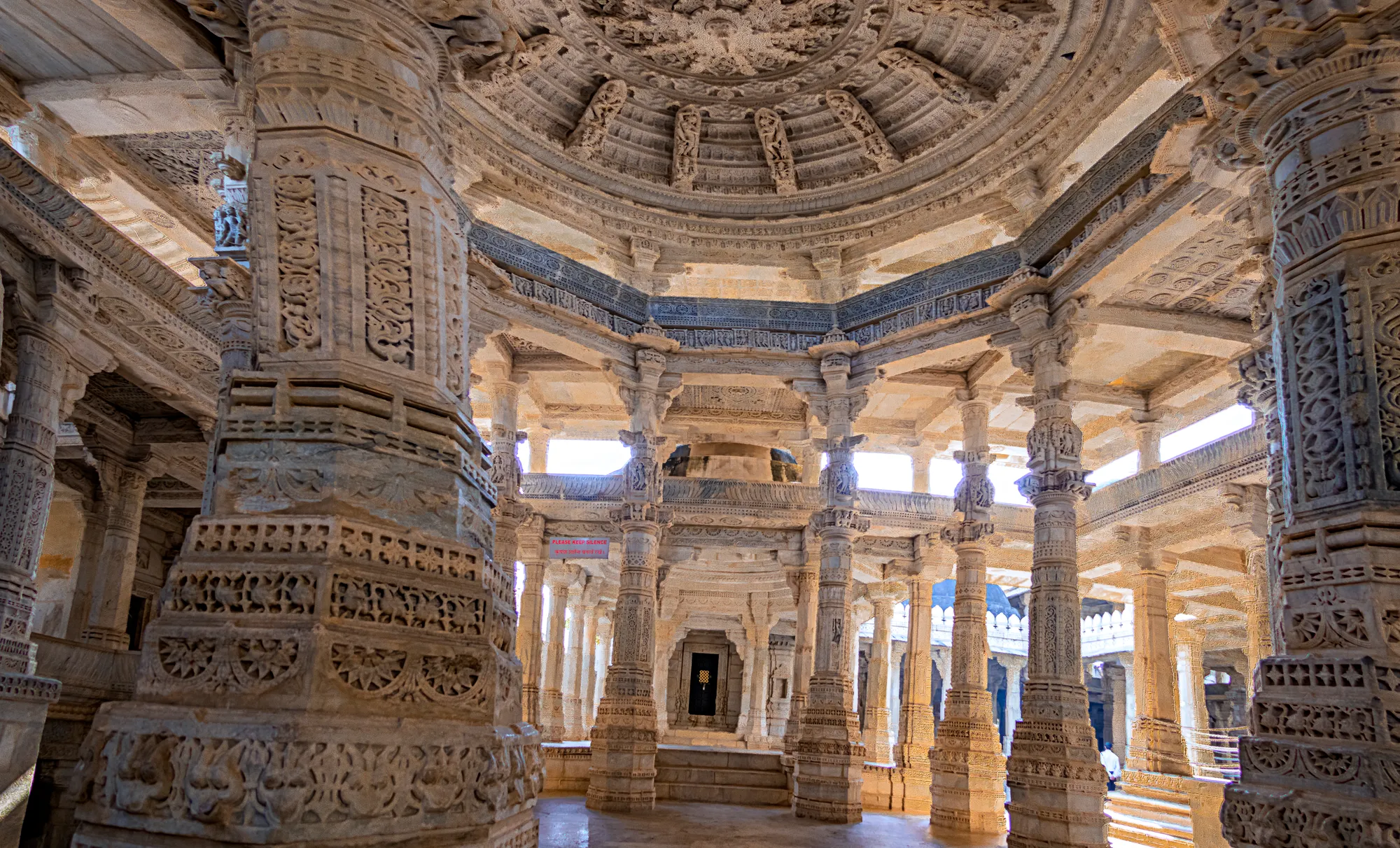 A carved white marble hall with a domed ceiling and many pillars